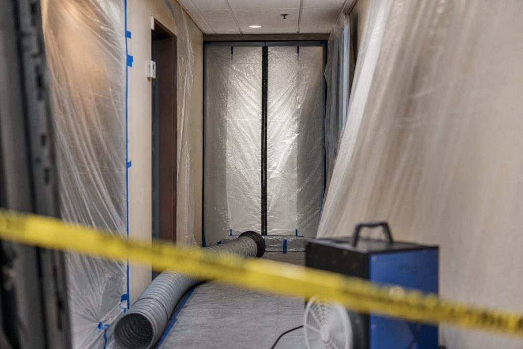 Mold containment with zipper door installed in a hallway during remediation